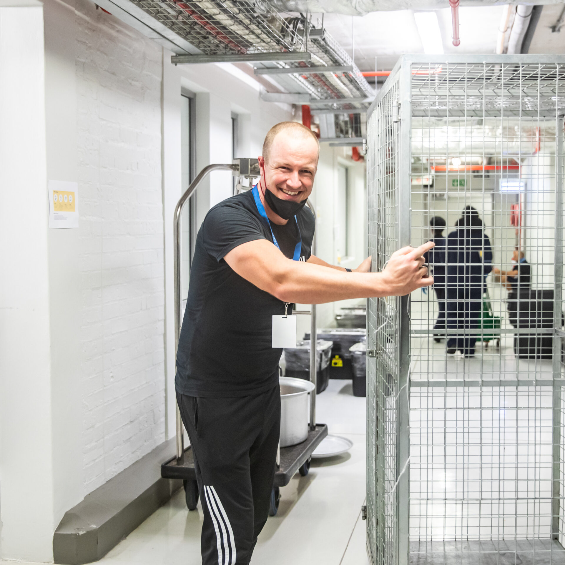 Smiling volunteer pushes an empty trolley through the Ladles of Love warehouse